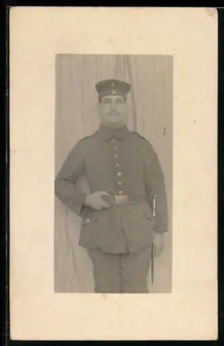 Foto-AK Soldat in Feldgrau Uniform mit Krätzchen und Bajonett