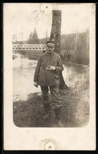 Foto-AK Soldat in Feldgrau Uniform mit Schirmmütze
