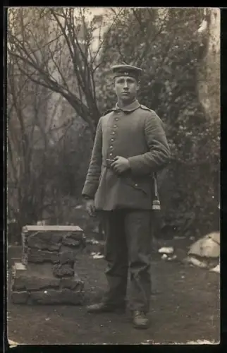 Foto-AK Soldat in Feldgrau Uniform mit Krätzchen und Bajonett