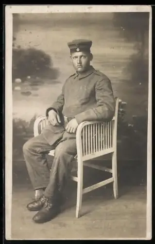 Foto-AK Soldat in Feldgrau Uniform mit verdeckter Knopfleiste und Krätzchen