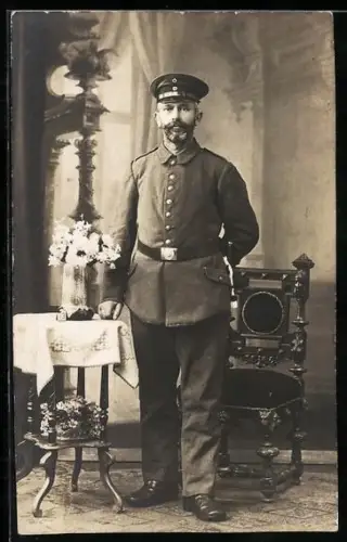 Foto-AK Soldat in Feldgrau Uniform mit Schirmmütze und Bajonett