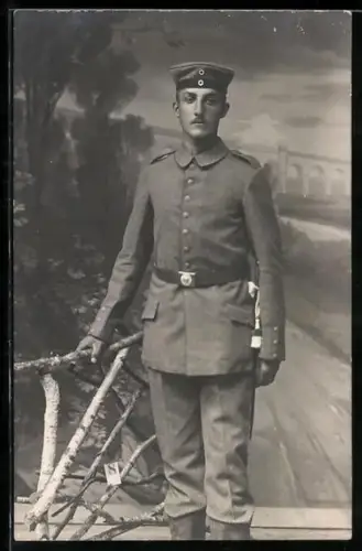Foto-AK Soldat in Feldgrau Uniform mit Krätzchen und Bajonett