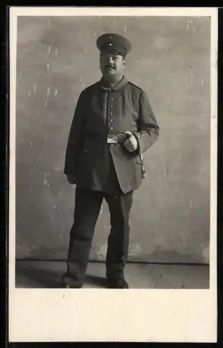 Foto-AK Soldat in Feldgrau Uniform mit Schirmmütze und Bajonett