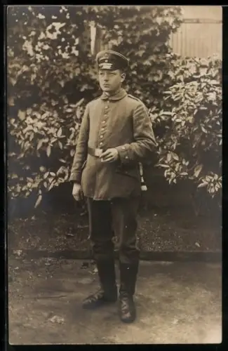 Foto-AK Soldat in Feldgrau Uniform mit Schirmmütze und Bajonett