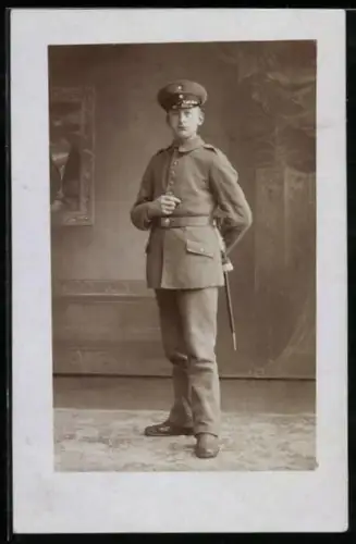 Foto-AK Soldat in Feldgrau Uniform mit Schirmmütze und Bajonett