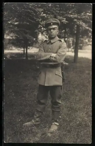 Foto-AK Soldat in Feldgrau Uniform mit Schirmmütze und Bajonett