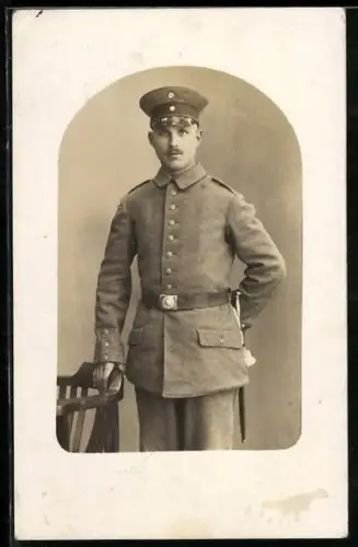 Foto-AK Soldat in Feldgrau Uniform mit Schirmmütze und Bajonett