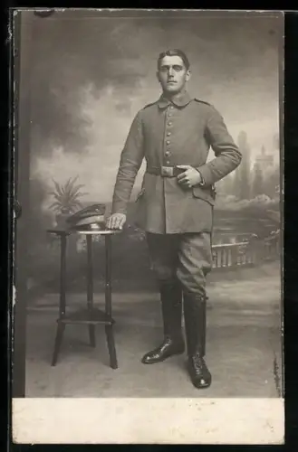 Foto-AK Soldat in Feldgrau Uniform mit Schirmmütze und Bajonett