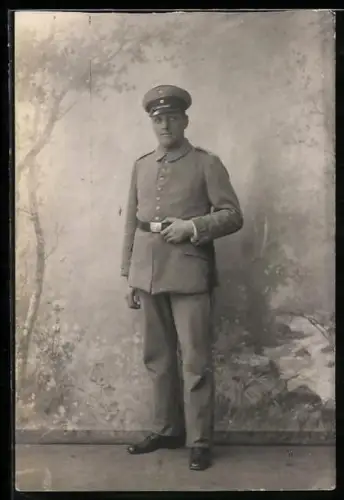 Foto-AK Soldat in Feldgrau Uniform mit Schirmmütze und Bajonett