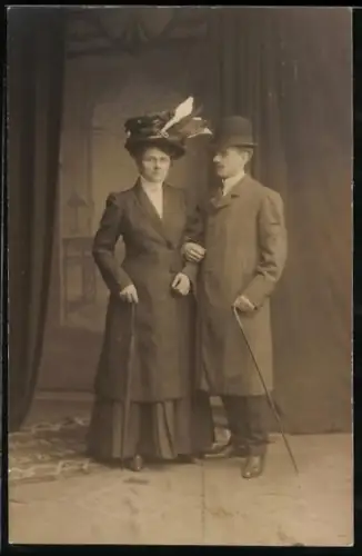 Foto-AK Paar in Mänteln vor einer Studiokulisse