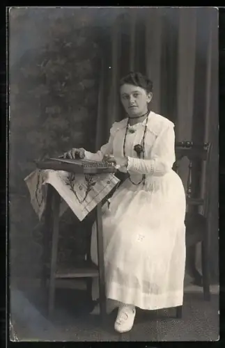 Foto-AK Sitzende Dame in elegantem Kleid mit Zither