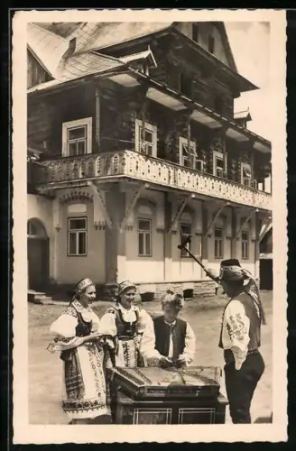 AK Zwei Männer und zwei Frauen in Trachten vor einem Haus mit Zither