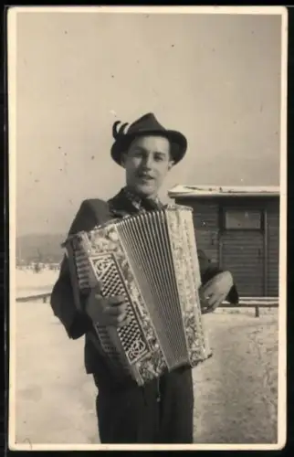 Foto-AK Junger Mann mit Akkordeon vor einem Haus