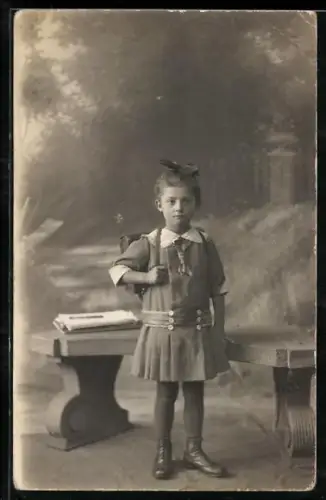 Foto-AK Kleines Mädchen mit Schultasche vor einer Bank