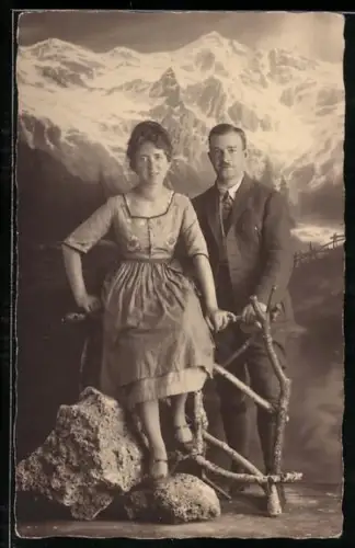Foto-AK Elegantes Paar posiert zusammen vor einer Bergkulisse