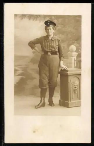 Foto-AK Dame mit Hut und Hose posiert neben einem Podest