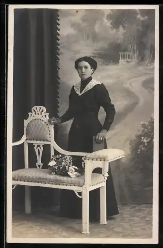 Foto-AK Elegante Dame mit Buch posiert bei einer Bank