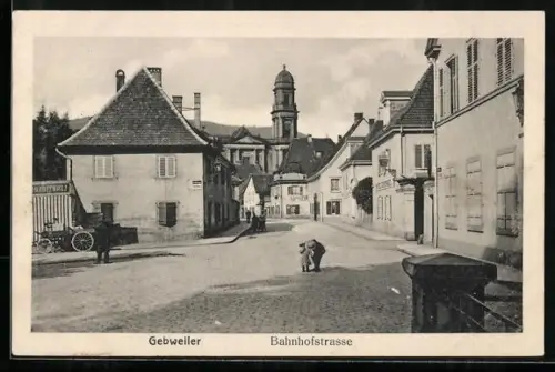 AK Guebwiller, la rue de la gare, l`église au fond, personnes