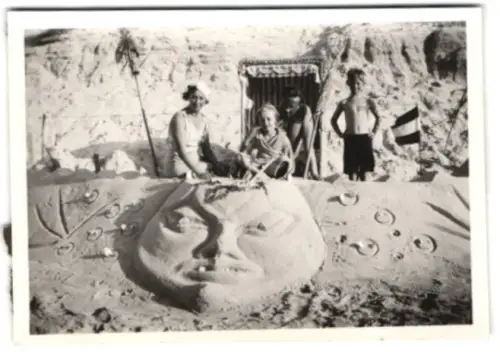 Fotografie junger Knabe in Badehose und Schwester am Strand mit Sandskulptur