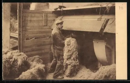 AK Mann vor einer Maschine bei der Verarbeitung von Flachs