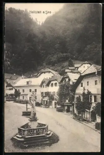 AK Hallstatt a. See, Strasse mit Brunnen, Häusern und Bergkulisse