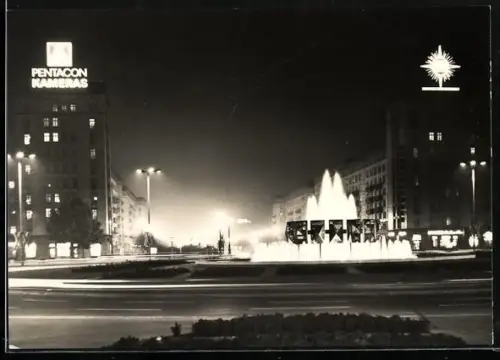 AK Berlin, Strausberger Platz mit Geschäfthäusern bei Nacht