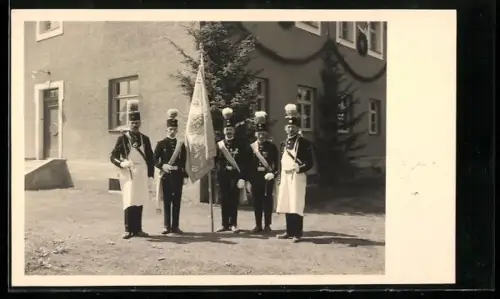 Foto-AK Bergleute in Uniform mit Fahne vor einem geschmückten Gebäude
