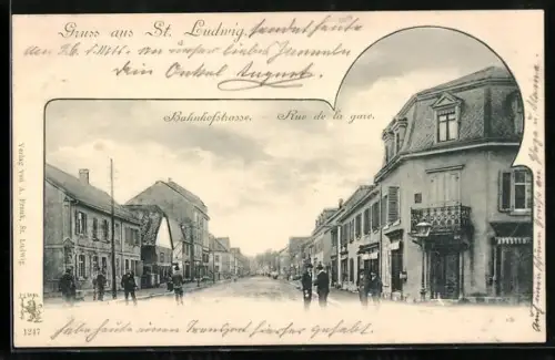 AK St. Ludwig, Rue de la gare avec bâtiments et passants
