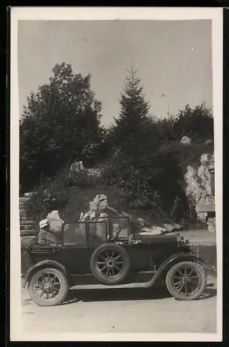 Foto-AK Cabriolet wird von Dr. Leopold Berger chauffiert, Auto, im Hintergrund Stein mit Inschrift Saalfelden