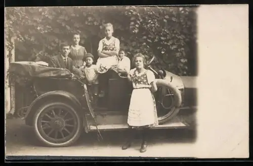 Foto-AK Auto mit einklappbarem Verdeck und Familie auf einem Grundstück