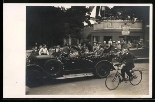 AK Auto mit Blätterschmuck und Fahradfahrer auf gepflasterter Strasse
