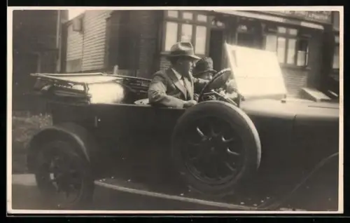 Foto-AK Auto mit heruntergeklapptem Verdeck mit Herr und Dame vor einer Ausfahrt