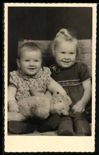 Foto-AK Zwei lächelnde Kinder mit einem Teddy