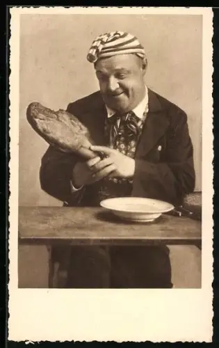 AK Mann sitzt an einem Tisch und hält eine Schweinshaxe