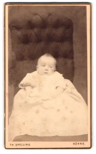 Fotografie Th. Spelling, Rønne, Lille Torv, Porträt eines Kleinkindes auf einem gepolsterten Stuhl