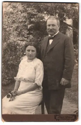 Fotografie Louis Brand, Schötmar, Sitzende Dame und stehender Herr im Freien