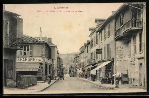 AK Decazeville, Rue de la Gare animée avec magasins et enseignes
