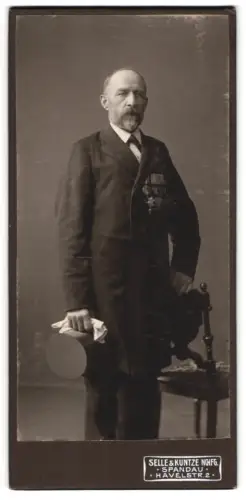 Fotografie Selle & Kuntze Nachf., Spandau, Veteran im Anzug mit Zylinder und grosser Ordensspange