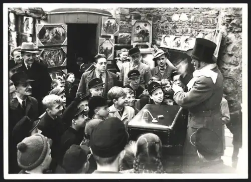 Fotografie Strassen Zauberer füht seine Zaubertricks vor Kindern auf