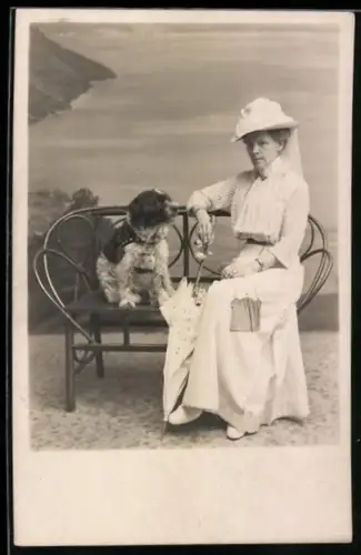 Foto-AK Ältere Dame sitzt mit einem Terrier auf einer Bank