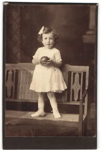 Fotografie unbekannter Fotograf und Ort, Kleines Kind mit Ball auf einer Bank