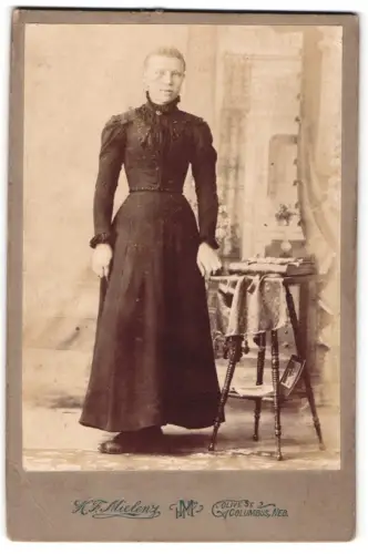 Fotografie K. P. Mielenz, Columbus, Olive St, Frau in elegantem Kleid neben Tisch