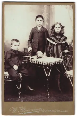 Fotografie W. Brüning, Varel, Am Bahnhof, Drei Kinder um einen Tisch gruppiert