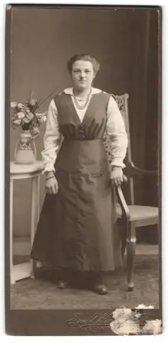 Fotografie Emil W., Ort unbekannt, Frau neben Tisch mit Blumenvase