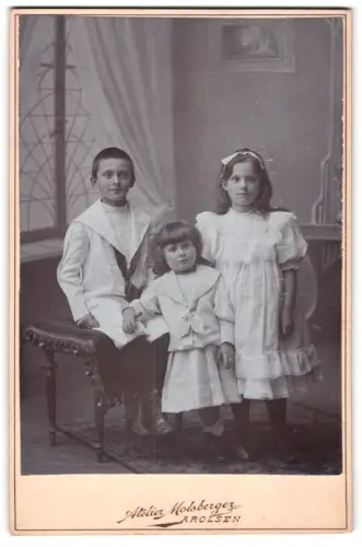 Fotografie Atelier Molsberger, Arolsen, Geschwister Josef, Lieschen und Alfons an einem Hocker