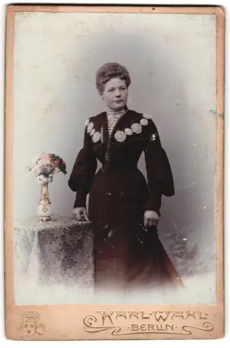 Fotografie Karl Wahl, Berlin, Grossgörschenstr. 1, Elegante Dame neben einem dekorativen Tisch