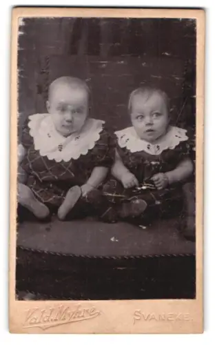 Fotografie Vald. Myhre, Svaneke, Zwei sitzende Kleinkinder mit Spitzenkragen