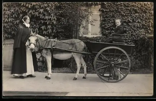 Foto-AK Dame und Kind mit Eselwagen vor einem Gebäude