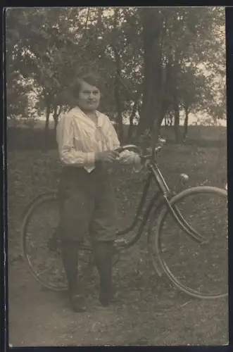 Foto-AK Frau mit ihrem Fahrrad in einer Parklandschaft