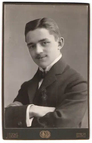 Fotografie J. Fuchs, Berlin, N. Friedrichstr. 108, Porträt eines jungen Mannes mit verschränkten Armen